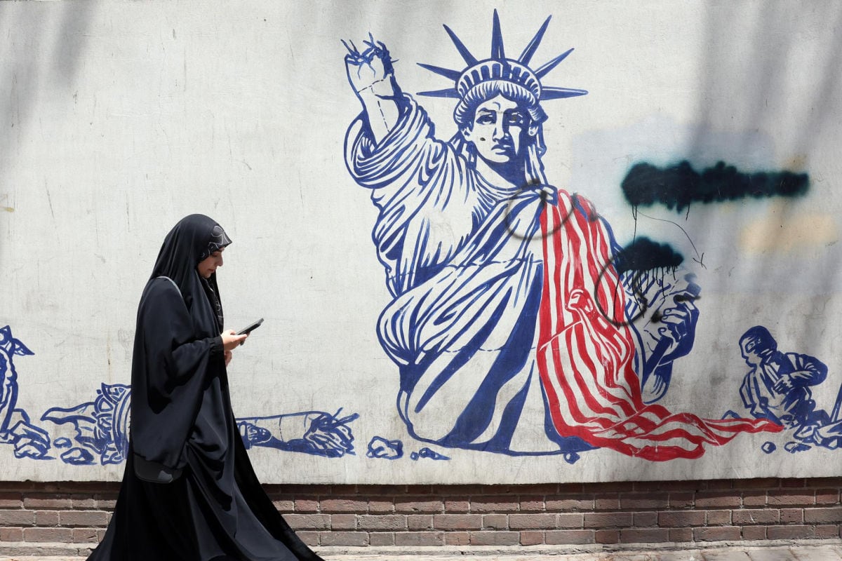 Una mujer pasa junto a un mural antiestadounidense cerca de la antigua embajada de EE. UU. en Teherán, Irán. Irán y EE. UU. intercambiaron disparos después de que el presidente estadounidense Trump declarara que el alto el fuego había terminado. Foto: EFE/ABEDIN TAHERKENAREH