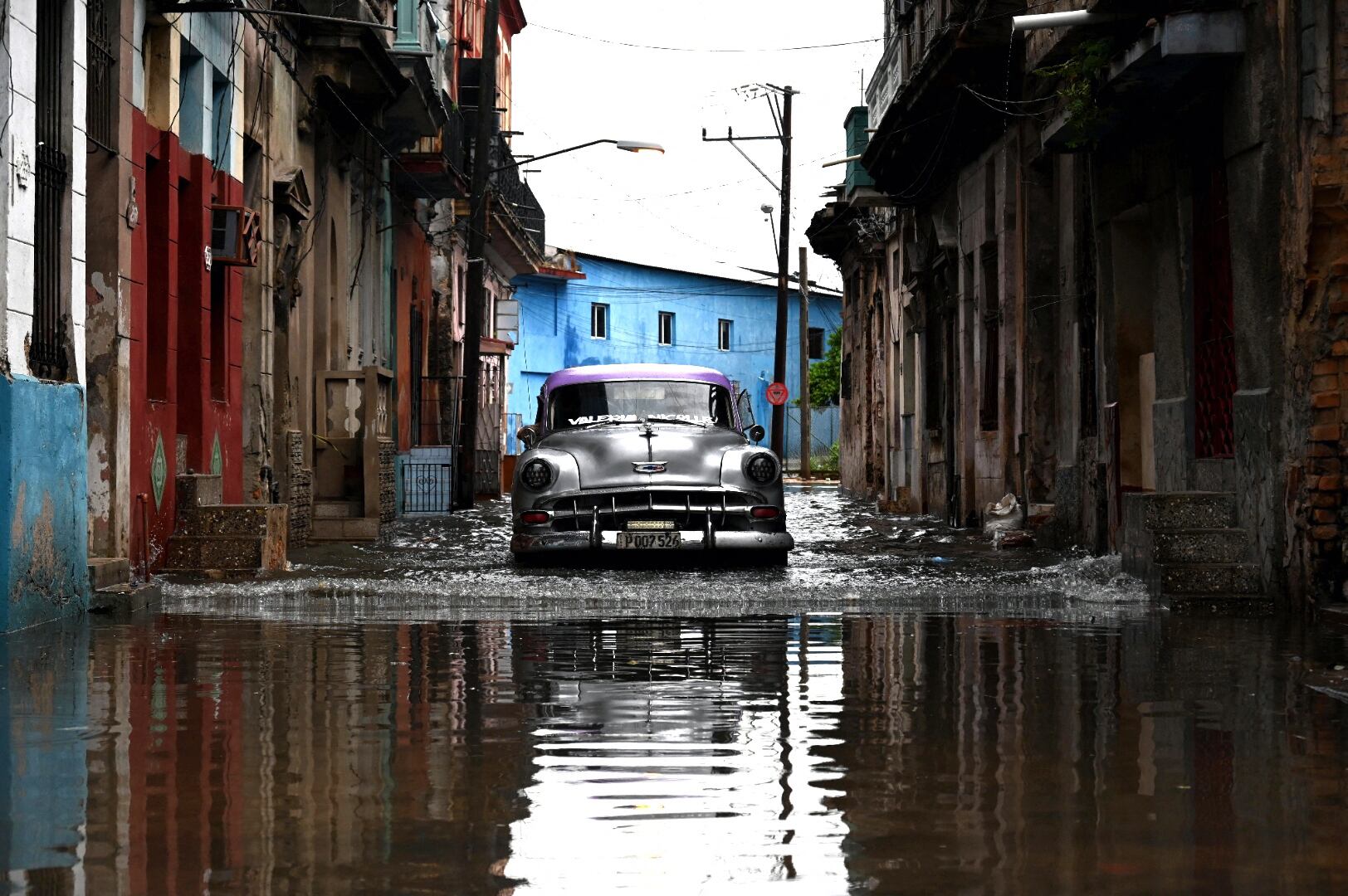 Un viejo automóvil circula por una calle inundada en La Habana, Cuba, el 29 de agosto de 2023, durante el paso del huracán Idalia. (Foto de Yamil LAGE / AFP).