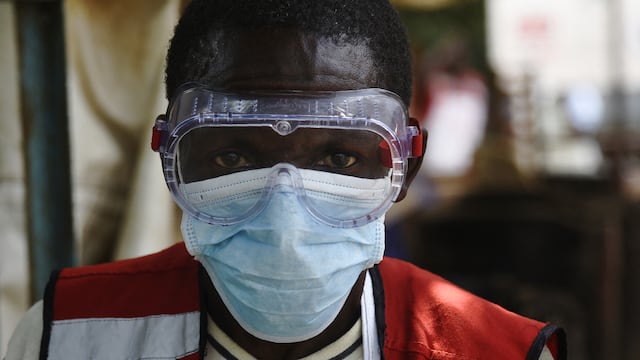 Un trabajador de la salud usa equipo de protección en el Centro de Detección de Salud de Mpondwe, en la frontera de Uganda con la República Democrática del Congo, el 13 de junio de 2019. (Foto de ISAAC KASAMANI / AFP).