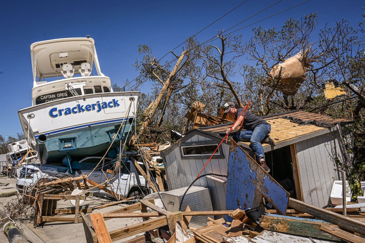 La gente limpia los escombros después de que el huracán Ian destruyera Fort Myers Beach, en Florida. (GIORGIO VIERA / AFP).