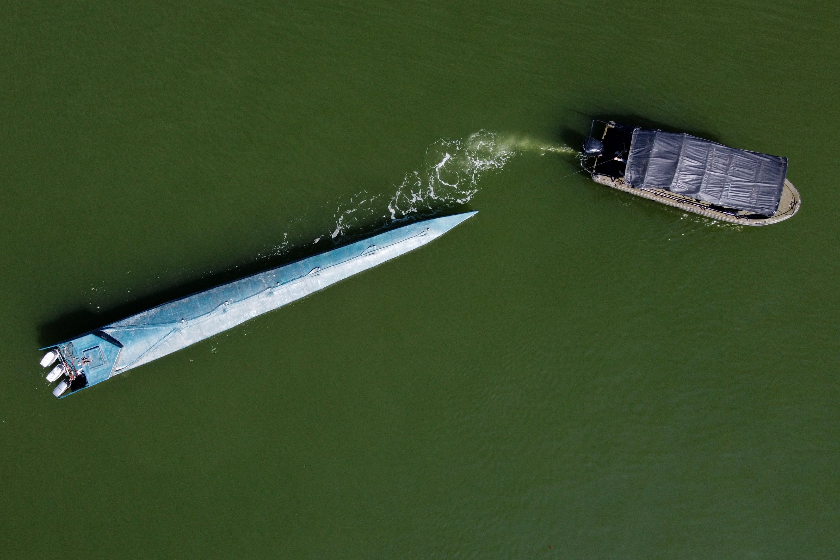 Un narcosubmarino incautado que es remolcado por un buque de la Armada de Colombia en Buenaventura, departamento del Valle del Cauca, el 21 de marzo de 2021. (Foto de Luis ROBAYO / AFP).
