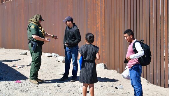 Un oficial de la Patrulla Fronteriza de EE. UU. trata con migrantes que llegan a la frontera entre Estados Unidos y México entre Algodones, México y Yuma, Arizona, el 16 de mayo de 2022. (Foto de Frederic J. BROWN / AFP)