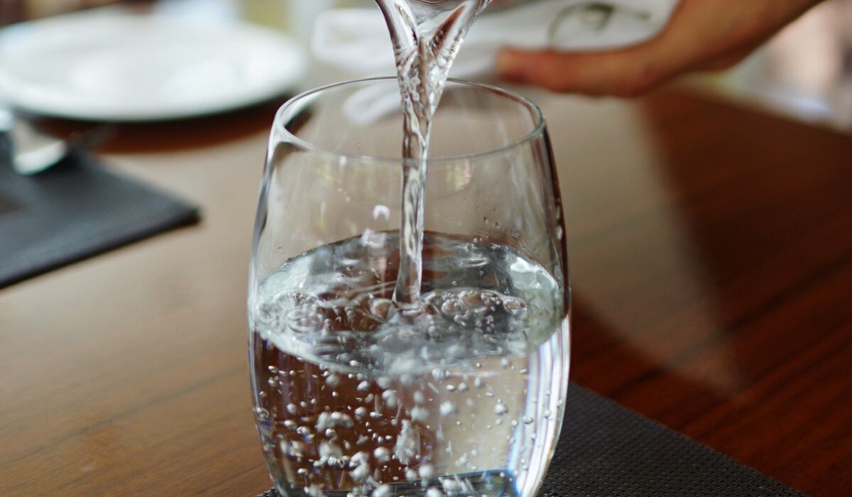 Una persona coloca agua sobre un vaso de vidrio. (Imagen: Pixabay)
