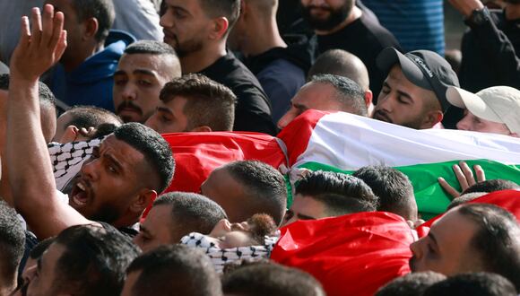Los dolientes cargan el cuerpo de uno de los dos palestinos muertos durante enfrentamientos con el ejército israelí en el campo de refugiados de al-Jalazoun durante su funeral en la ciudad cisjordana de Ramallah el 23 de octubre de 2023, en medio de las batallas en curso entre Israel y el grupo islamista palestino Hamás. (Foto de Jaafar ASHTIYEH/AFP)