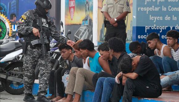 Un policía custodia hoy a los detenidos de un grupo armado por la toma temporal de un canal de televisión ayer, en Guayaquil (Ecuador) | Foto: EFE/ Carlos Durán Araújo