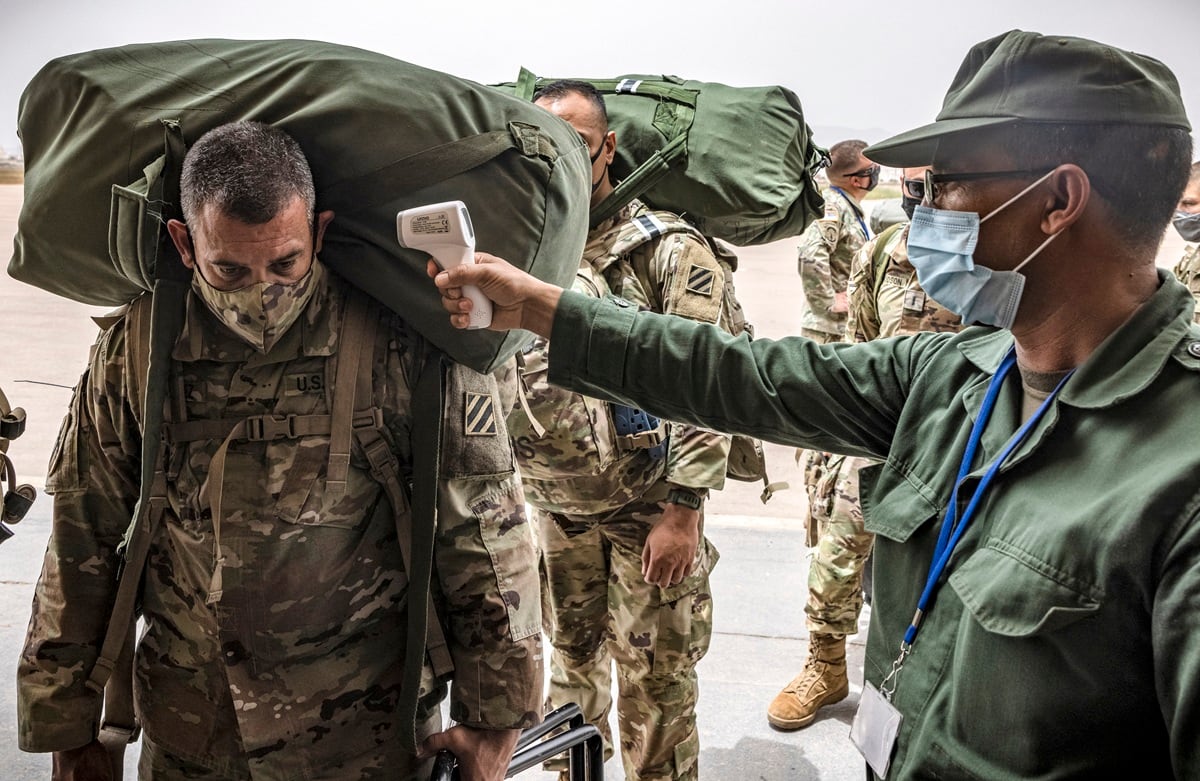 Un soldado del ejército estadounidense es examinado con un termómetro infrarrojo como parte de las medidas de detección del coronavirus COVID-19, a su llegada al aeropuerto militar de Agadir en Marruecos, el 9 de junio de 2021. (Foto de FADEL SENNA / AFP)