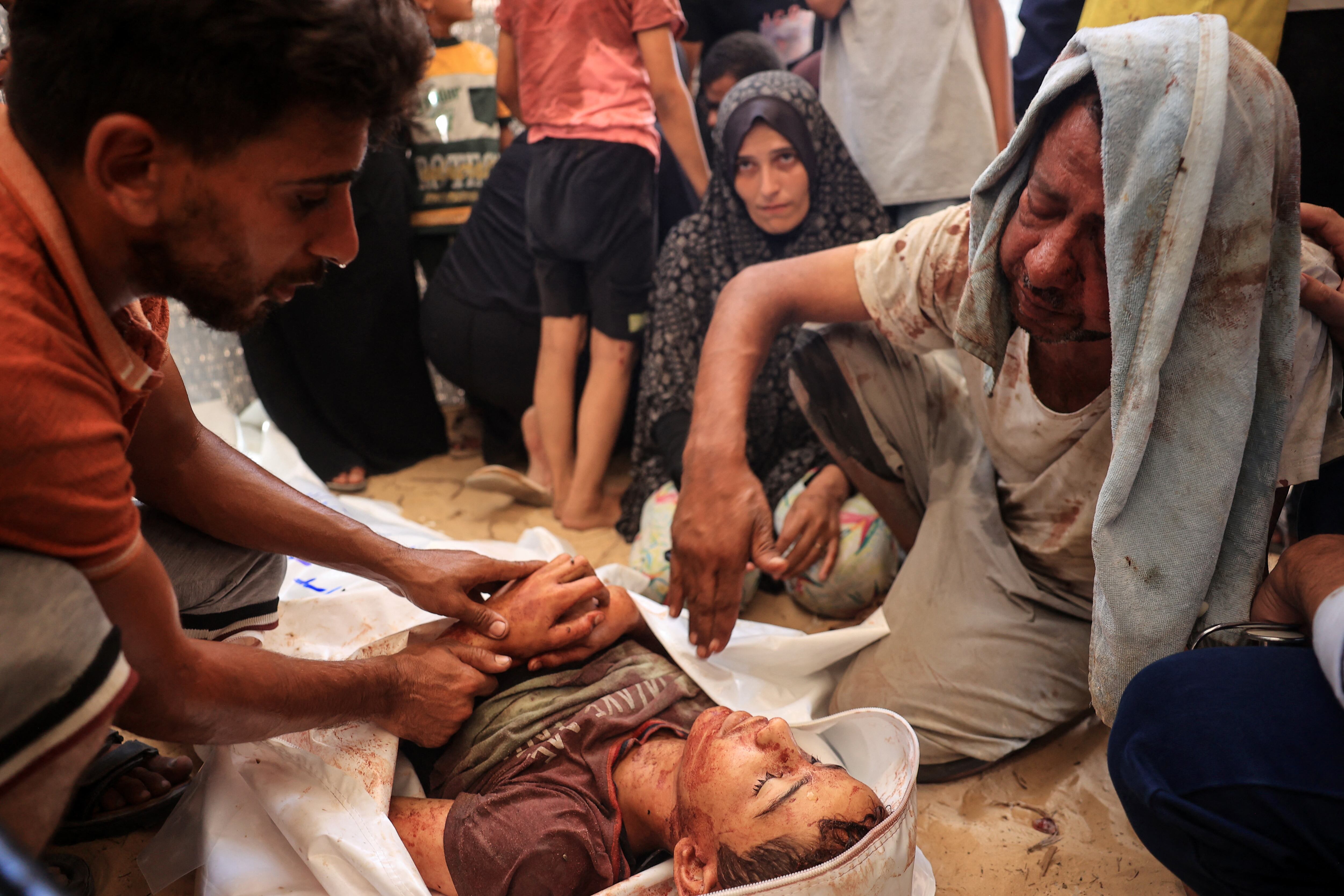 Palestinos rodean el cadáver de un niño frente a la morgue del hospital Nasser en Khan Yunis el 13 de julio de 2024. (Foto de Eyad BABA / AFP)