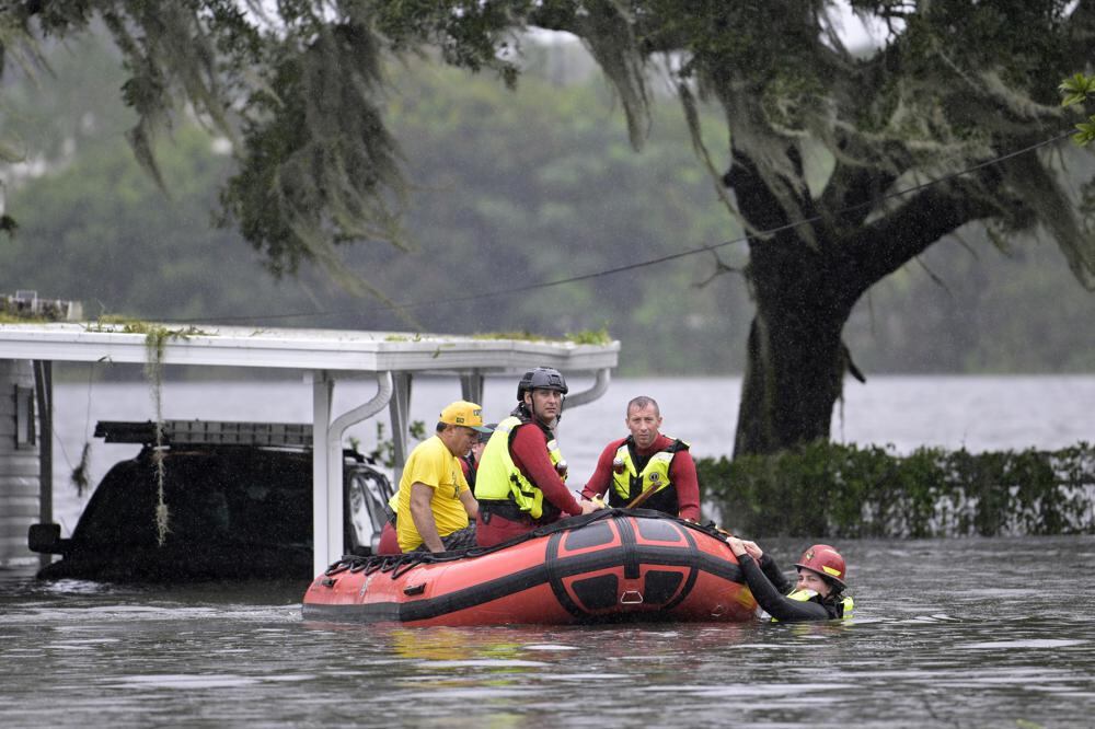 Los socorristas del Cuerpo de Bomberos del Condado de Orange usan un bote inflable para rescatar a un residente de una casa tras el impacto del huracán Ian en Florida. (AP Photo/Phelan M. Ebenhack).