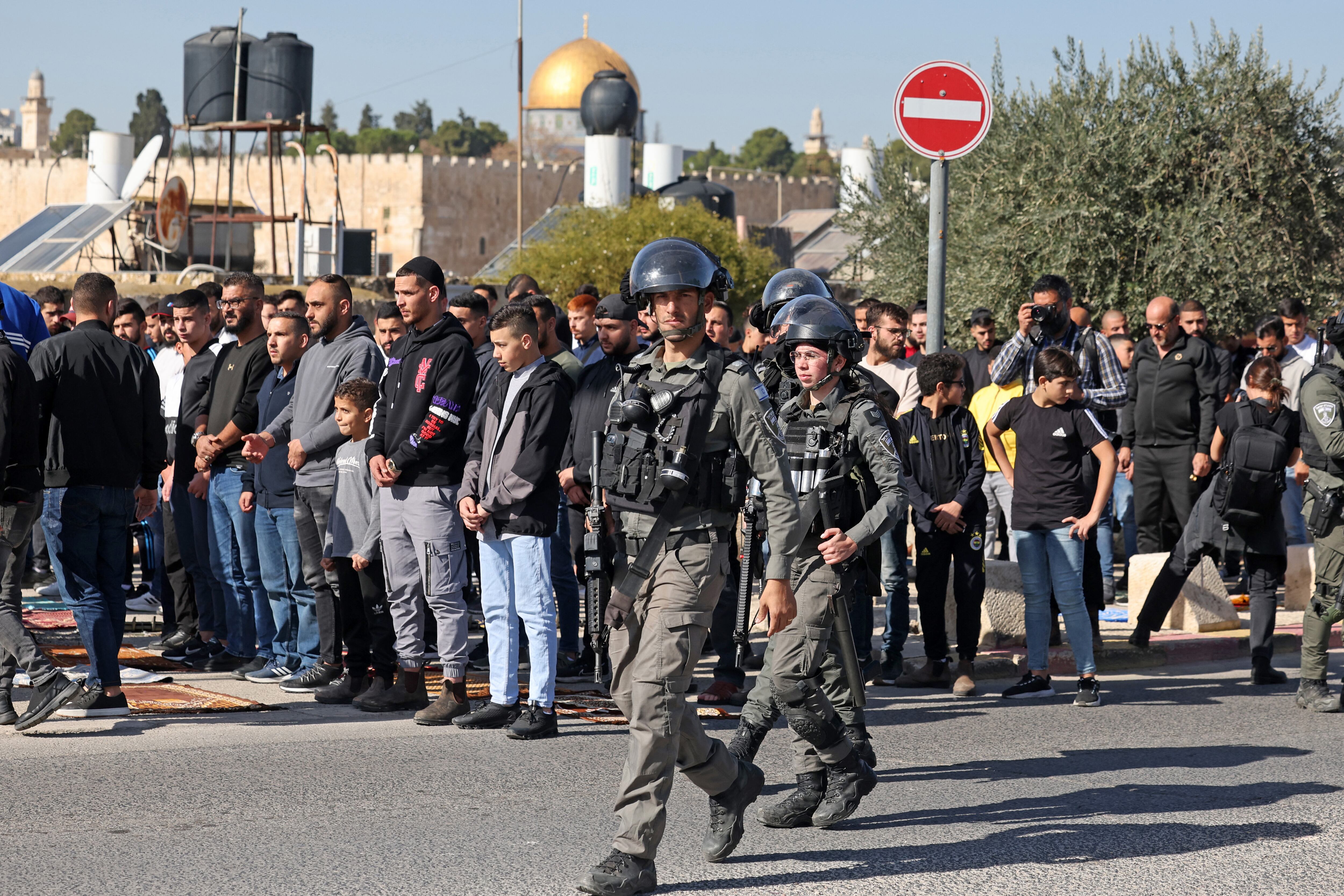 Las fuerzas israelíes patrullan la zona mientras los musulmanes palestinos realizan la oración del mediodía del viernes en la calle en el barrio de Ras al-Amud, en Jerusalén oriental, el 1 de diciembre de 2023 (Foto de AHMAD GHARABLI / AFP)