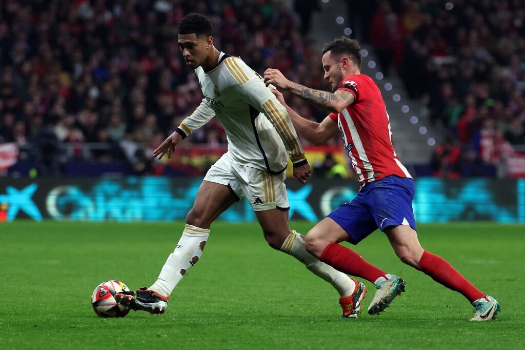 Real Madrid's English midfielder #5 Jude Bellingham (L) is challenged by Atletico Madrid's Spanish midfielder #08 Saul Niguez during the Spanish Copa del Rey (King's Cup) football match between Club Atletico de Madrid and Real Madrid CF at the Metropolitano stadium in Madrid on January 18, 2024. (Photo by Pierre-Philippe MARCOU / AFP)
