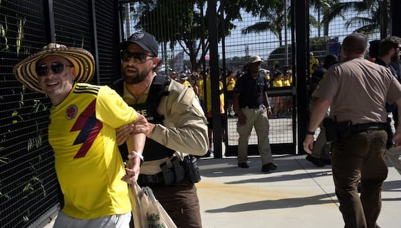 Security personnel detain a Colombia's supporter that tried to get into the stadium without tickets ahead of the Conmebol 2024 Copa America tournament final football match between Argentina and Colombia at the Hard Rock Stadium, in Miami, Florida on July 14, 2024. (Photo by JUAN MABROMATA / AFP)