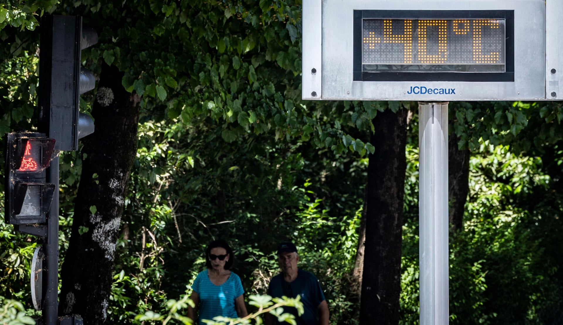 Una pareja pasa junto a un termómetro este lunes San Sebastián, España. Los cielos en Euskadi se presentan poco nubosos o despejados y con posibilidad de algún chubasco disperso tormentoso en el sur, en una nueva jornada de calor sofocante. (EFE/ Javier Etxezarreta).