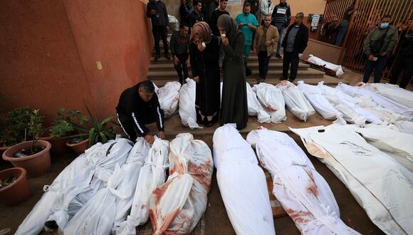 Los cuerpos amortajados de las personas que murieron en el bombardeo israelí en Khan Yunis, en el sur de la Franja de Gaza, frente a la morgue del hospital Al-Nasr el 19 de noviembre de 2023. (Foto de Mahmud HAMS / AFP)