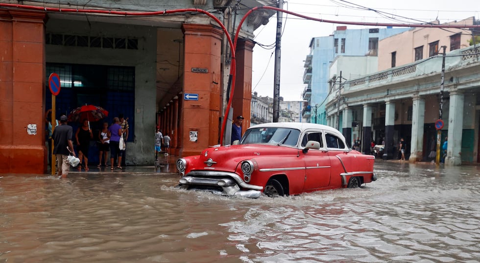 Un carro transita hoy por una calle inundada por el huracpan Idalia en La Habana, Cuba. (EFE/Ernesto Mastrascusa).