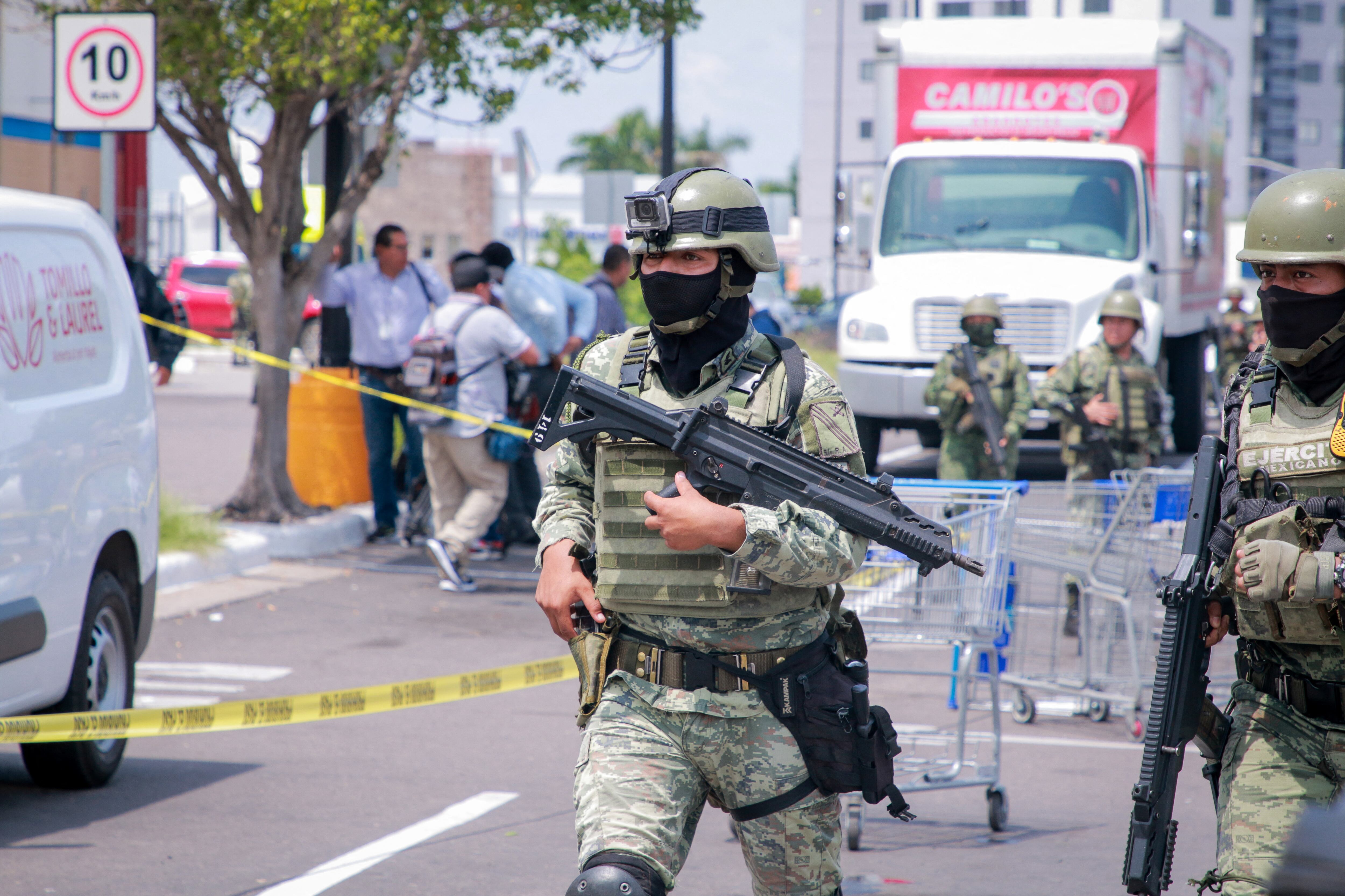 Miembros del Ejército Mexicano son vistos en el estacionamiento de una tienda donde se encontró el cuerpo de un hombre en el barrio Montebello de Culiacán, estado de Sinaloa, el 12 de septiembre de 2024. (Foto de Ivan MEDINA / AFP).
