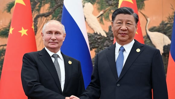 El presidente de Rusia, Vladimir Putin, y el presidente chino, Xi Jinping, se dan la mano durante una reunión en Beijing, el 18 de octubre de 2023. (Foto de Sergei GUNEYEV / POOL / AFP)