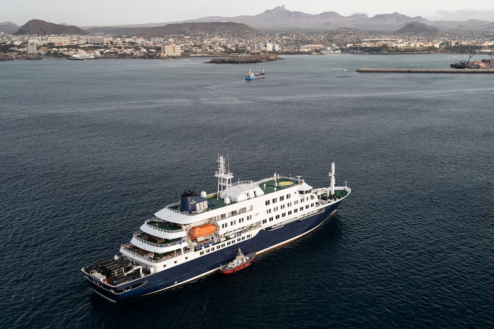 Esta vista aérea muestra al personal sanitario abordando el crucero MV Hondius, mientras se encontraba anclado frente al puerto de Praia, la capital de Cabo Verde, el 6 de mayo de 2026. (Foto: AFP).