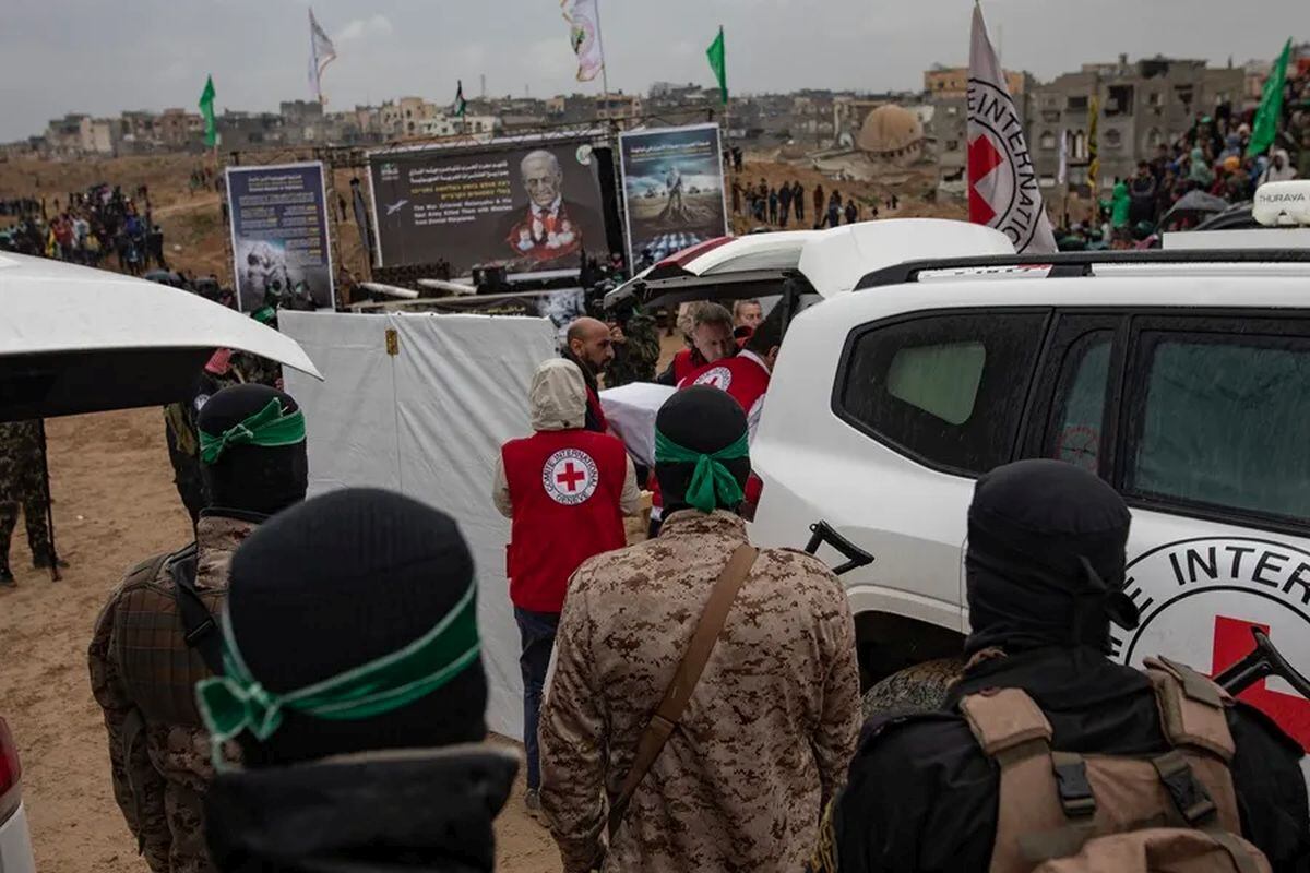 Miembros de la Cruz Roja introducen en un coche el féretro de uno de los rehenes entregados este jueves por Hamás en Gaza. Foto: EFE/EPA/Haitham Imad