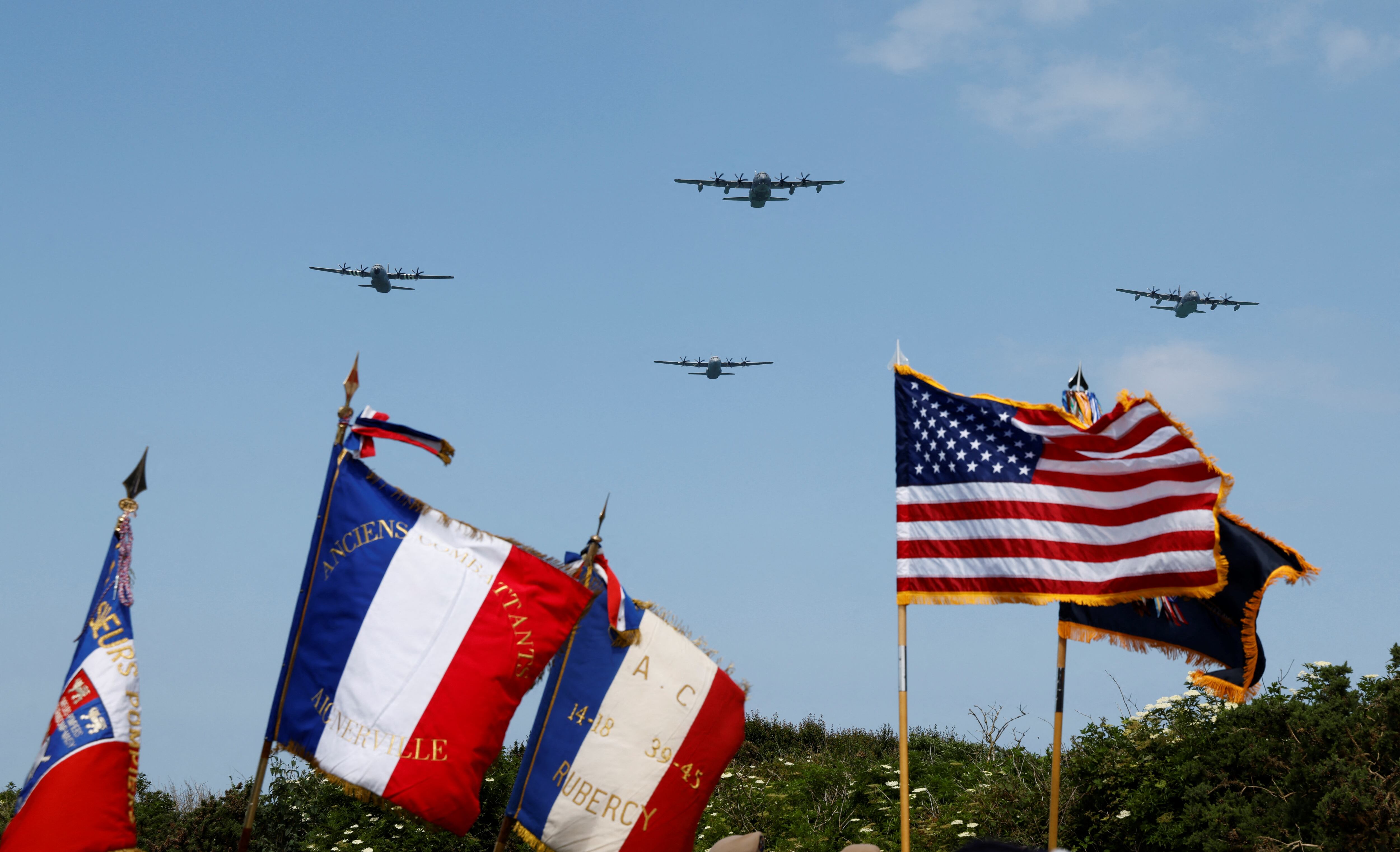 Aviones Lockheed C-130 Hercules sobrevuelan sobre banderas durante una ceremonia en lo alto del acantilado 'Pointe du Hoc' en Cricqueville-en-Bessin, noroeste de Francia, como parte de las conmemoraciones por el Día D. (Foto de Ludovic MARIN / AFP).