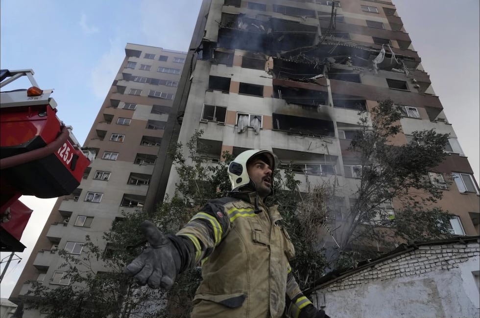 Un bombero llama a sus colegas en el lugar de una explosión en un complejo residencial en el norte de Teherán, Irán, el viernes 13 de junio de 2025, tras un ataque de Israel. (Foto AP/Vahid Salemi).