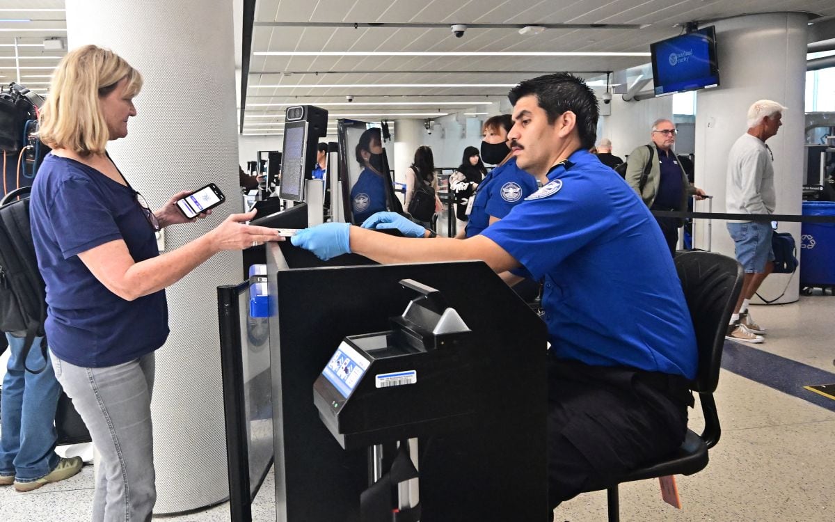 Una mujer entrega sus documentos de viaje a un agente de la TSA en el Aeropuerto Internacional de Los Ángeles el 7 de mayo de 2025 (Foto: Frederic J. Brown / AFP)