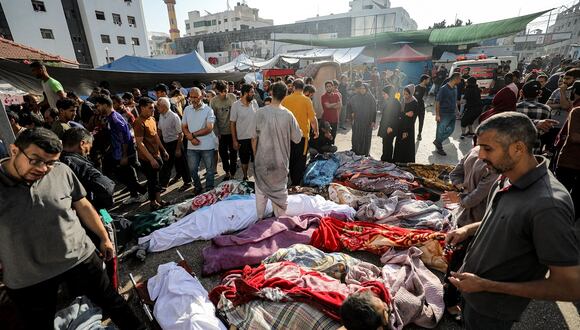 Gente inspecciona los cuerpos de las víctimas que murieron en el bombardeo israelí mientras yacen afuera del hospital Al-Shifa en la ciudad de Gaza el 8 de noviembre de 2023. (Foto de Dawood NEMER / AFP)