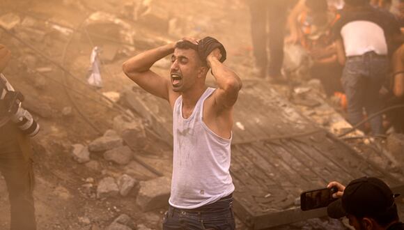 Un palestino reacciona mientras otros revisan los escombros de un edificio en Khan Yunis el 6 de noviembre de 2023, en medio de las batallas en curso entre Israel y el grupo palestino Hamás. (Foto de MAHMUD HAMS / AFP)