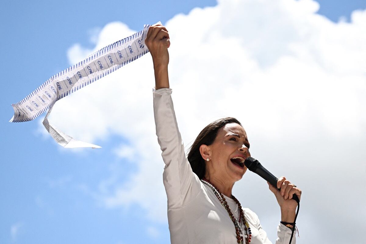 La líder de la oposición venezolana, María Corina Machado, habla con sus partidarios mientras sostiene registros electorales durante una manifestación en Caracas, el 28 de agosto de 2024. (Foto de JUAN BARRETO / AFP)
