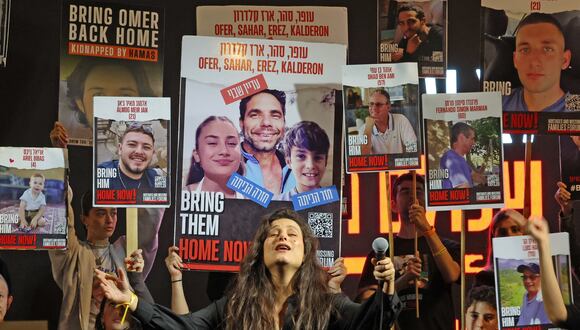 Manifestantes levantan pancartas y retratos durante una marcha en Tel Aviv, en diciembre pasado, pidiendo la liberación de los rehenes israelíes retenidos en Gaza por Hamas. (Foto de AHMAD GHARABLI / AFP).