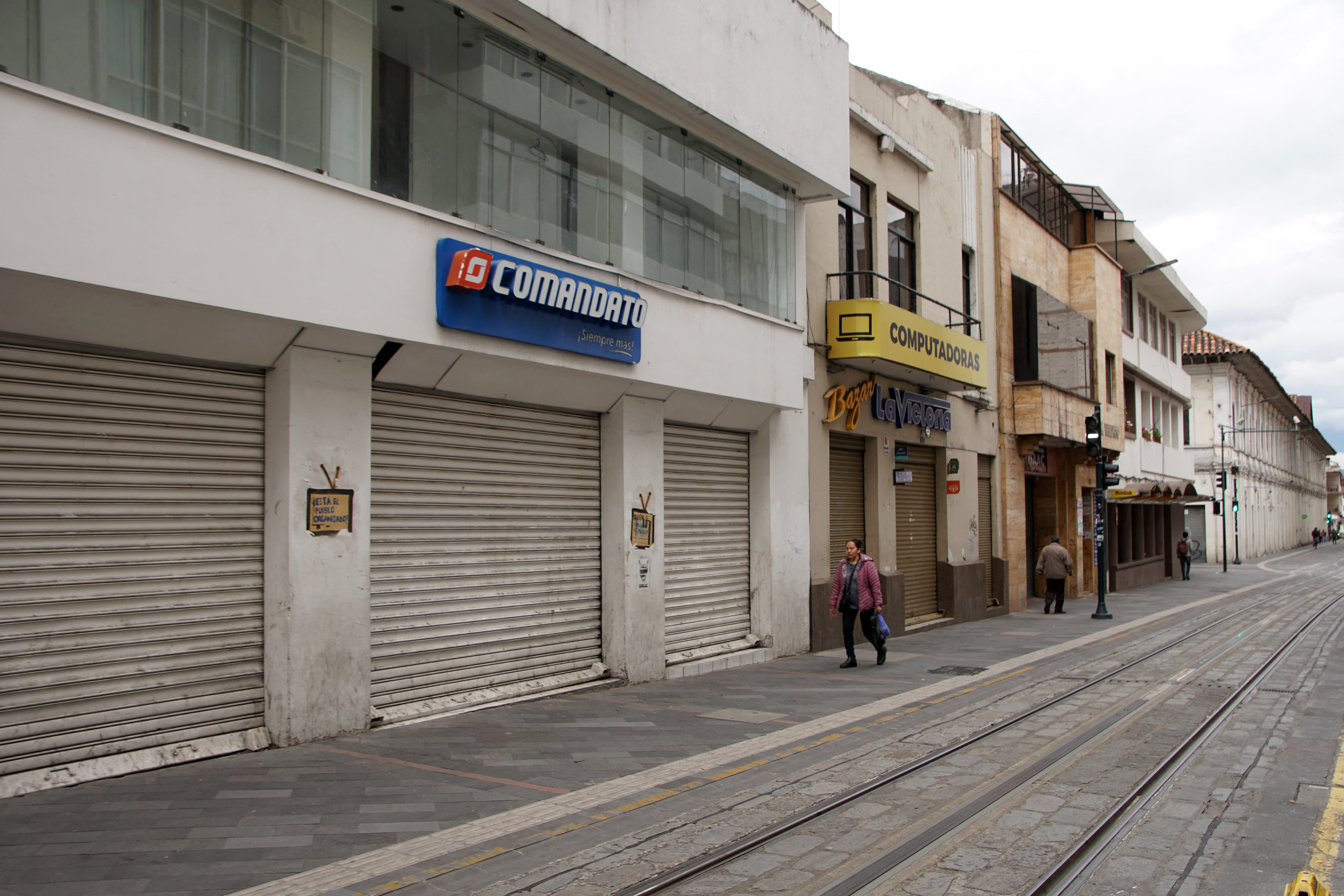 Una mujer camina por una calle desierta en Cuenca, Ecuador. (Foto de Fernando Machado / AFP)