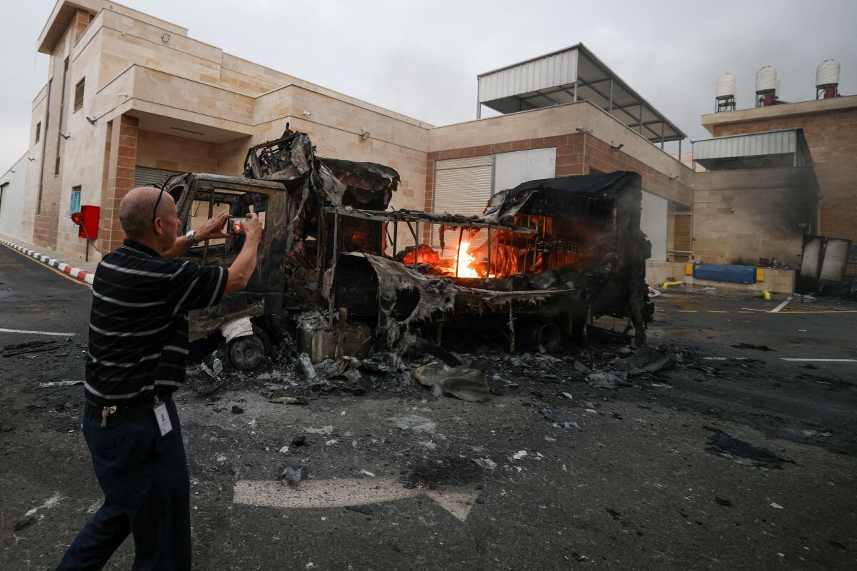Un palestino graba con su teléfono móvil un camión en llamas tras un ataque de colonos israelíes en la aldea de Beit Lid, al este de Tulkarm, en la Cisjordania ocupada, el 11 de noviembre de 2025. Foto: JAAFAR ASHTIYEH / AFP
