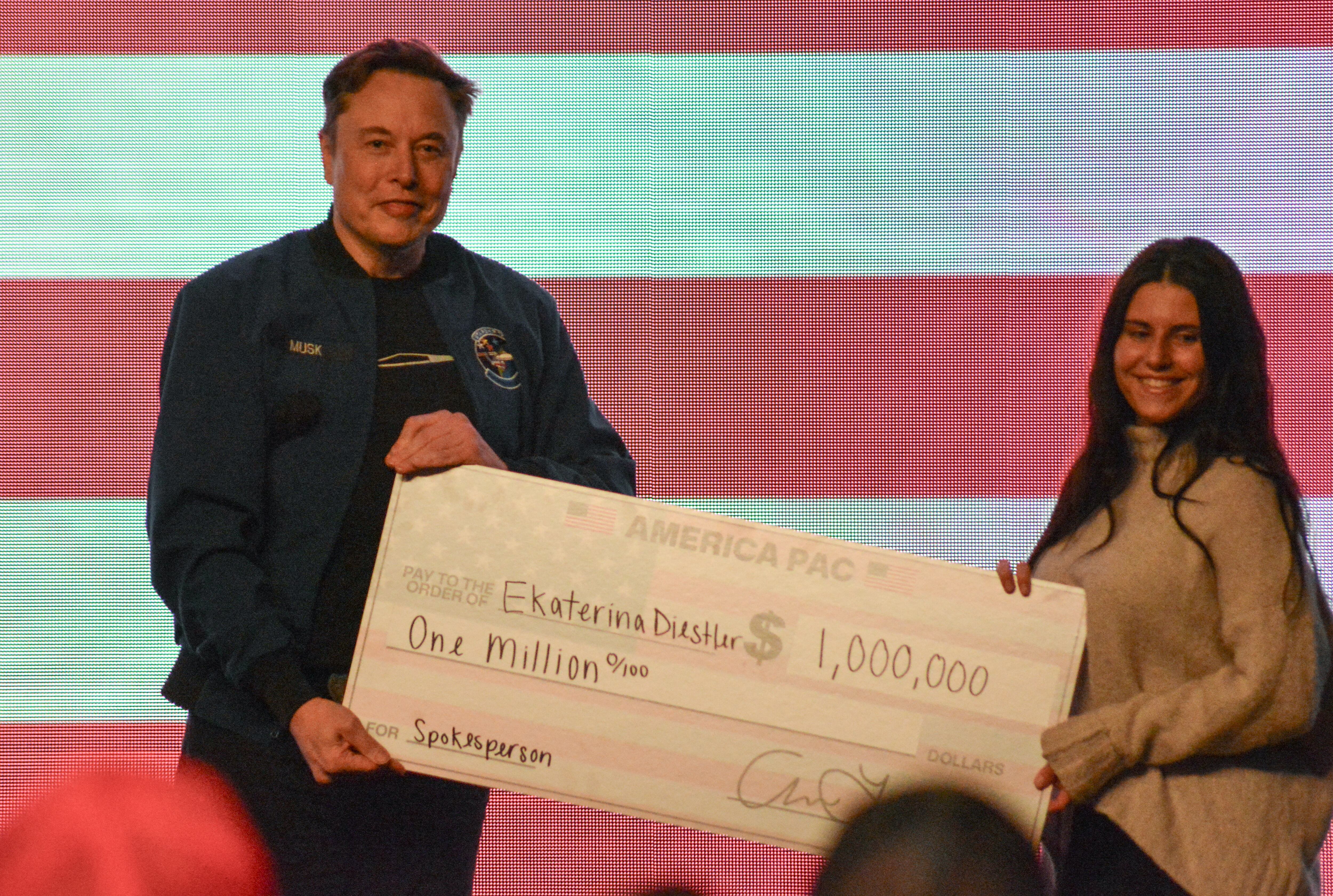 En la foto, Elon Musk dándole un millón de dólares a Ekaterina Diesler, durante un evento en Wisconsin. (Foto: AFP)