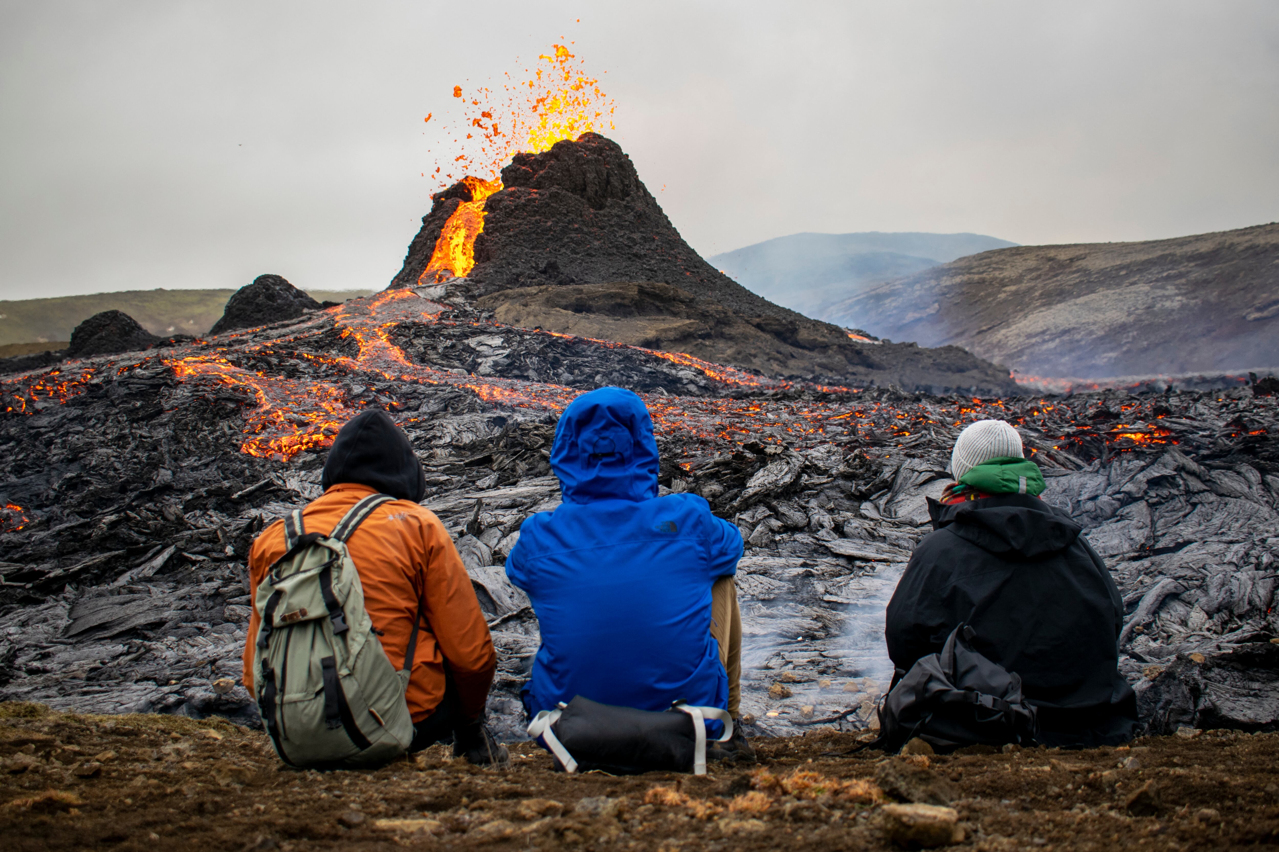 Los excursionistas observan la lava que fluye del volcán Fagradalsfjall en erupción el 21 de marzo de 2021. (Foto de Jeremie RICHARD / AFP).
