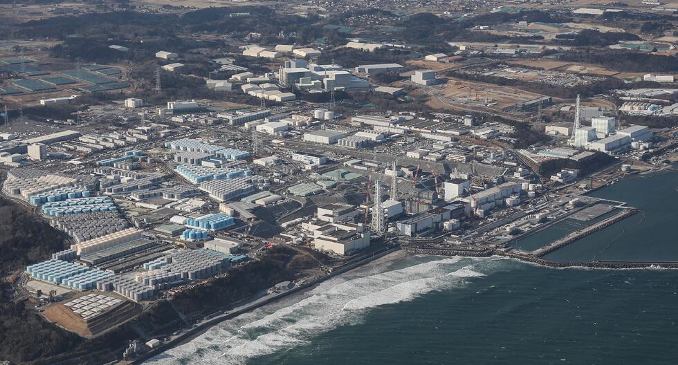 Esta fotografía aérea tomada por Jiji Press el 14 de febrero de 2021 muestra una vista de la accidentada central nuclear de Fukushima Daiichi de TEPCO, así como de los tanques (L) utilizados para almacenar las aguas residuales tratadas, a lo largo de la costa de Okuma, en la prefectura de Fukushima. (Foto: AFP)