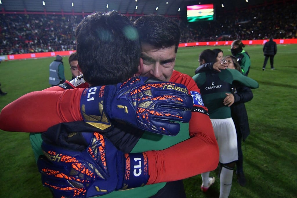 Bolivia's goalkeeper #01 Carlos Lampe (R) celebrates with a teammate after winning the 2026 FIFA World Cup South American qualifiers football match between Bolivia and Brazil at the Municipal de El Alto Stadium in El Alto, Bolivia on September 9, 2025. (Photo by Daniel MIRANDA / AFP)