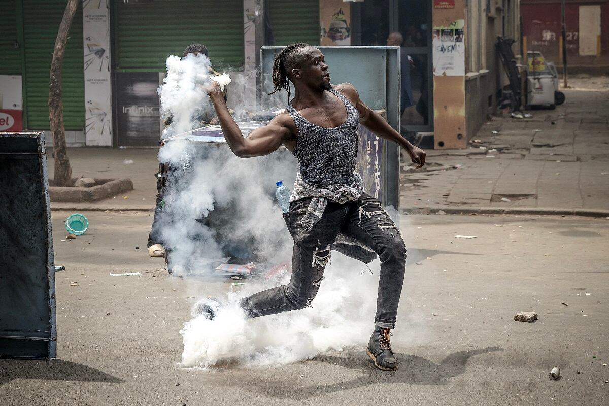 Un manifestante arroja un bote de gas lacrimógeno a los agentes de policía de Kenia en medio de enfrentamientos durante una manifestación antigubernamental en el centro de Nairobi, el 2 de julio de 2024. (Foto de LUIS TATO / AFP)
