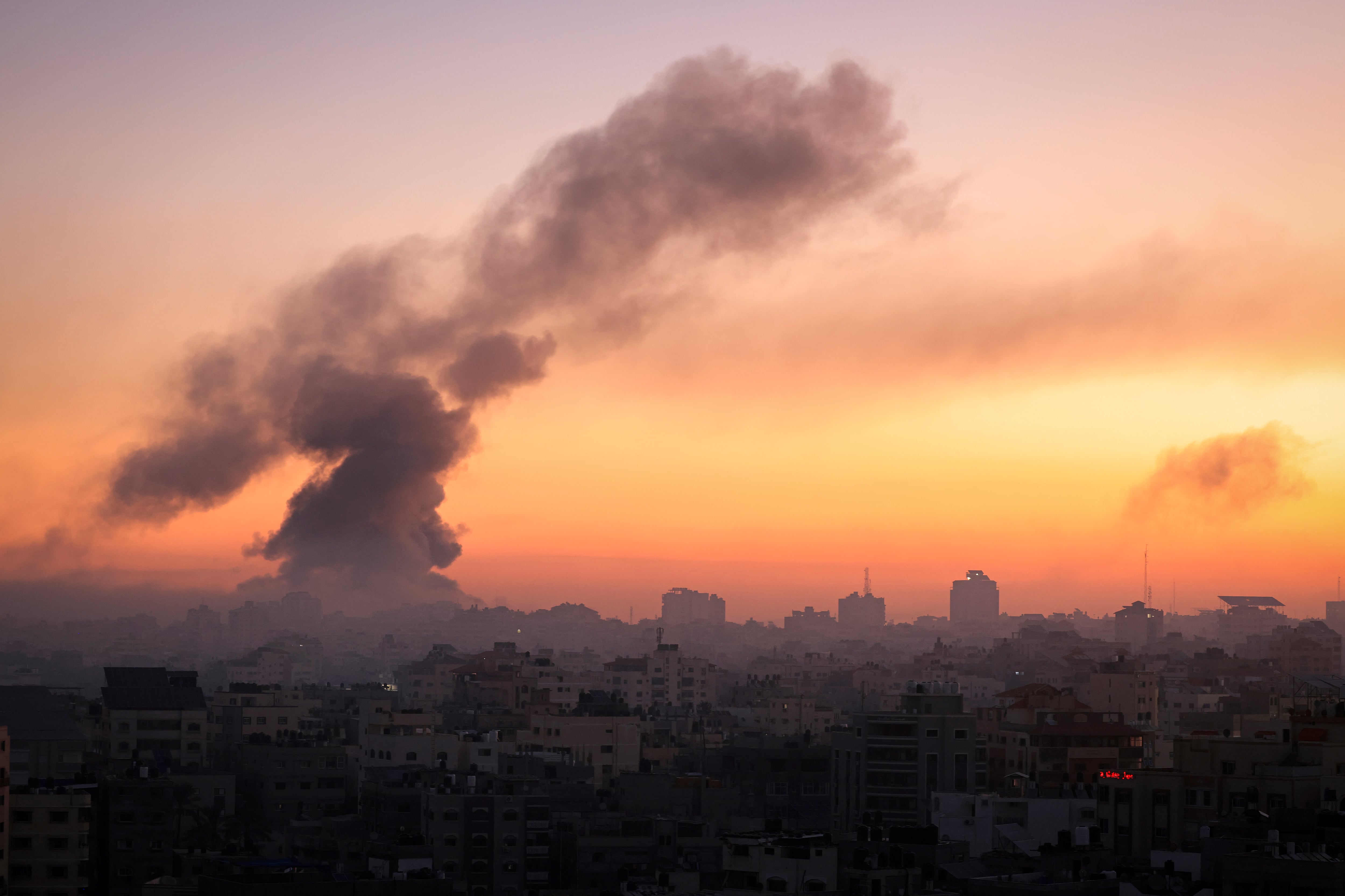 El fuego y el humo se elevan sobre los edificios de la ciudad de Gaza durante un ataque aéreo de Israel el 13 de octubre de 2023. (Foto de MAHMUD HAMS / AFP).