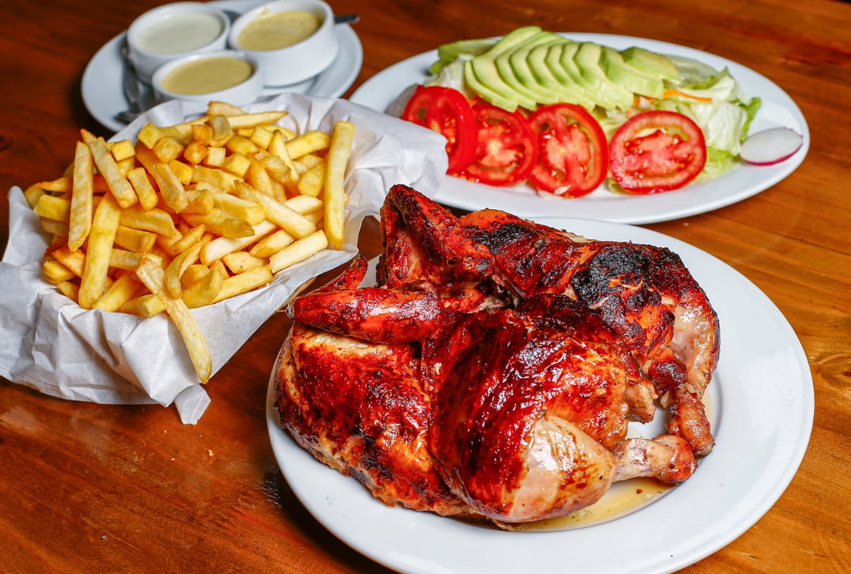 El pollo a la leña en Villa Chicken, siempre acompañado de las clásicas guarniciones: papas fritas y ensalada, junto a sus clásicas cremas.