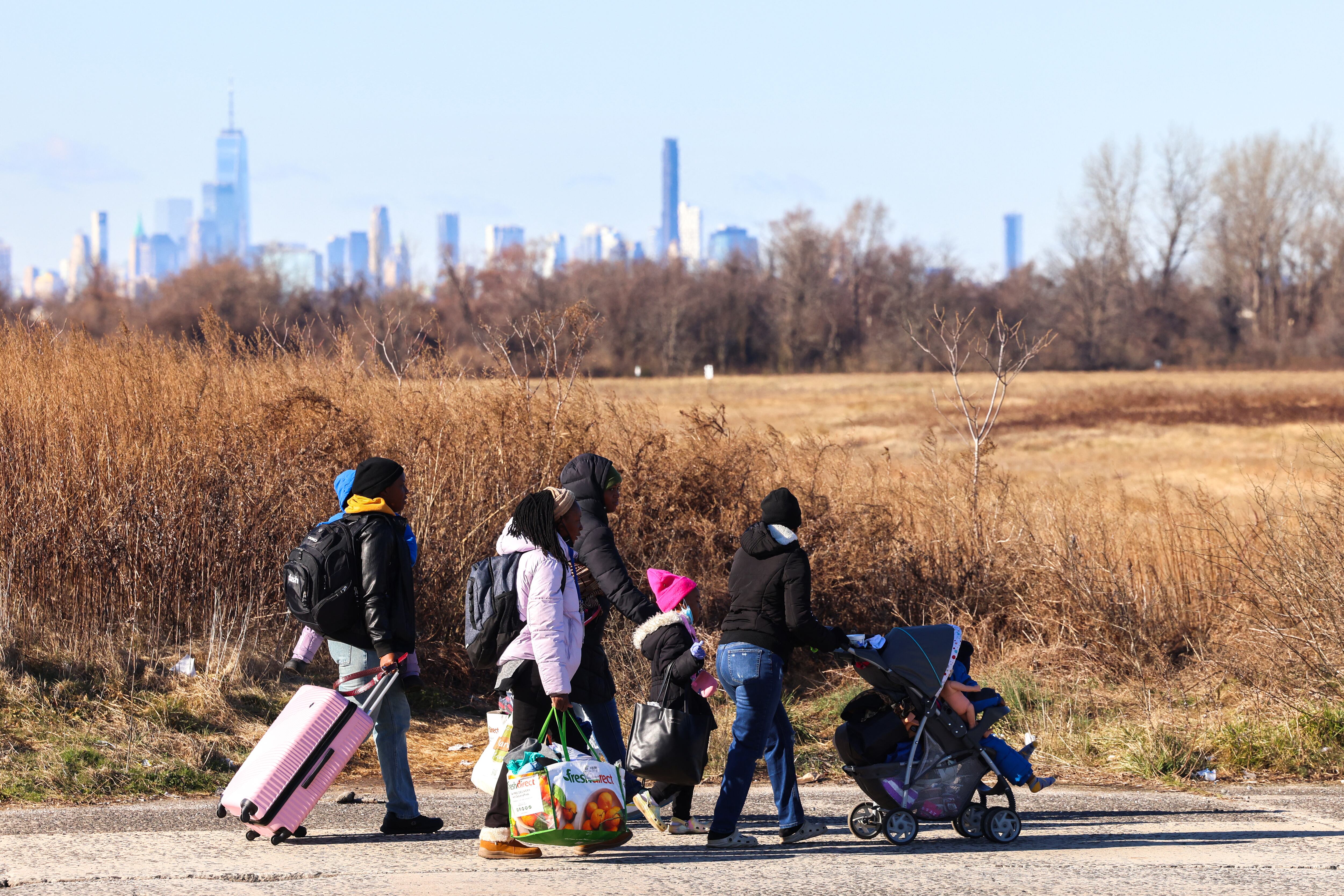 Los migrantes que llegaron hace unos días desde Eagle Pass, Texas, caminan hacia Floyd Bennett Field, en el distrito de Brooklyn, Nueva York. (Foto de Charly TRIBALLEAU / AFP)