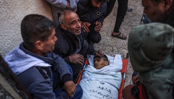 Familiares lloran junto al cuerpo del palestino Ibrahim Abu Libda, asesinado durante los ataques israelíes en Rafah, en el sur de la Franja de Gaza, el 26 de diciembre de 2023, en medio de batallas en curso entre Israel y el grupo militante Hamás. (Foto de SAID KHATIB / AFP)
