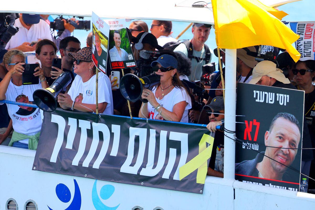 Members of the families of Israelis held hostage in the Gaza Strip since October 2023, sail on board a boat as it leaves the marina of the Israeli coastal city of Ashkelon on August 7, 2025. Relatives of Israeli hostages set sail on August 7 in a flotilla to approach the Gaza Strip, according to an AFP journalist aboard one vessel, with organisers saying they hoped to "get as close as possible to their loved ones". More than 20 people boarded several boats that departed from the coastal city of Ashkelon carrying yellow flags and posters bearing the images of the hostages, as they shouted their names. (Photo by Jack GUEZ / AFP)