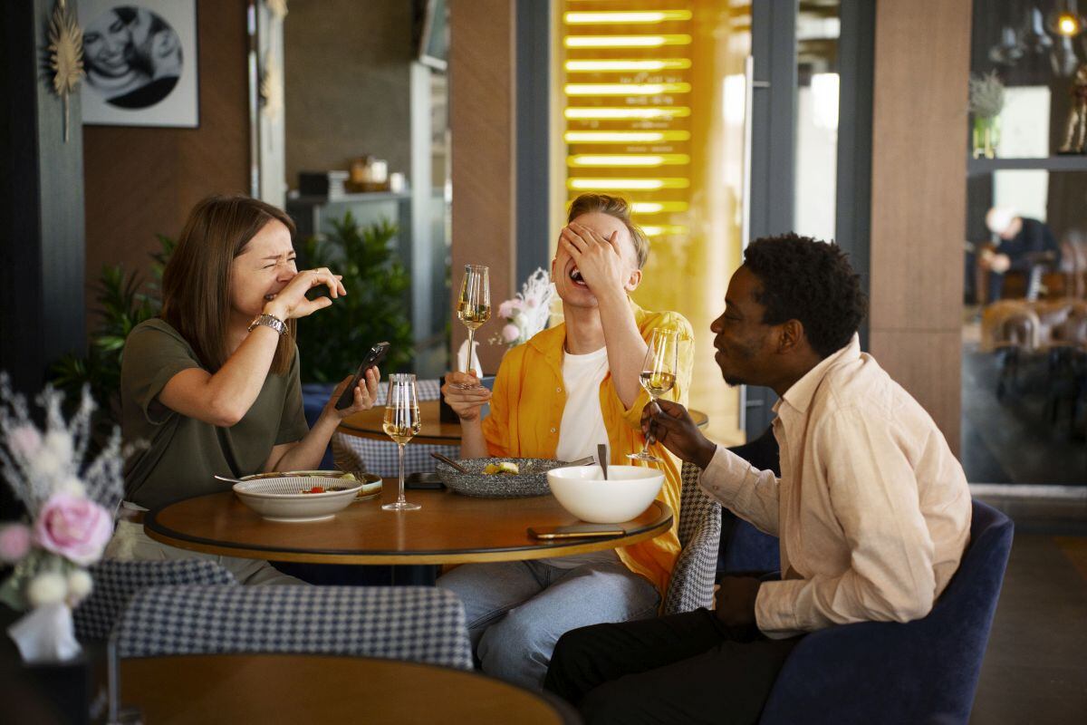 Un grupo de amigos comiendo en un restaurante. (Foto: Freepik)