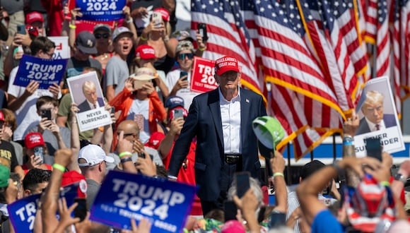 Sus partidarios sostienen carteles y hacen gestos mientras el ex presidente de Estados Unidos y candidato presidencial republicano Donald Trump. (Foto de Jim WATSON / AFP)