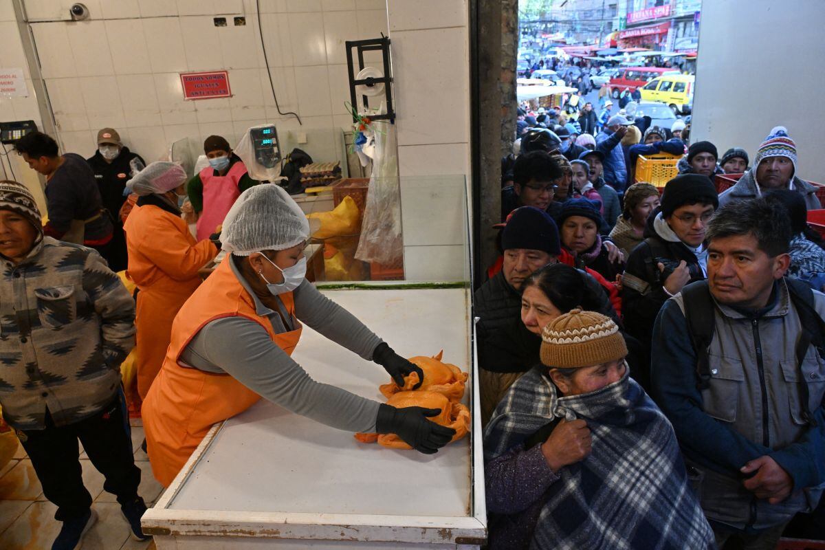 La gente hace fila temprano en la mañana para comprar pollo a un precio más bajo que en los mercados privados de La Paz el 11 de junio de 2025. (Foto de AIZAR RALDES / AFP)