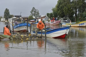 Pescadores preparan sus embarcaciones en una zona inundada de la ciudad costera de Arauco, región del Biobío, provincia de Arauco, Chile, el 16 de julio de 2026, tras las fuertes tormentas que azotaron la región. (GUILLERMO SALGADO / AFP)