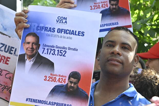 Un hombre muestra una pancarta con los resultados de las elecciones presidenciales de Venezuela del 28 de julio, según las actas conseguidas por la oposición. (Foto de Santiago Mazzarovich/AFP).