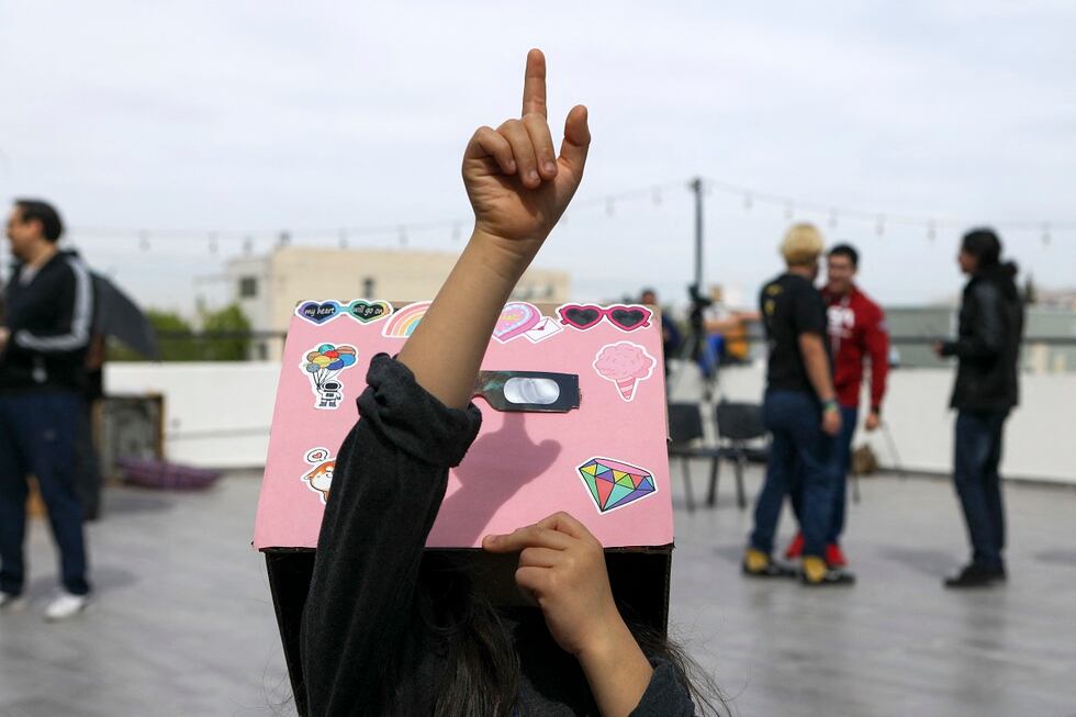 Una niña mira y señala hacia el cielo mientras la luna comienza a eclipsar parcialmente al sol en Ciudad Juárez, estado de Chihuahua, México, el 8 de abril de 2024. (Foto de HERIKA MARTINEZ / AFP)