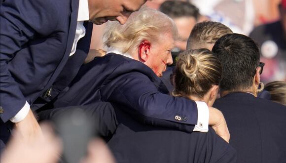 Donald Trump herido en la oreja es ayudado a bajar del escenario tras un atentado en un mitin en Butler, Pensilvania. (AP / Gene J. Puskar).