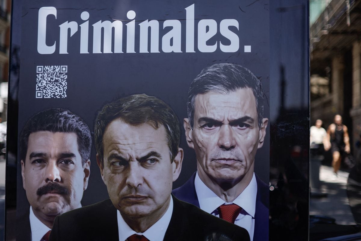 Un cartel en el que aparecen el presidente derrocado de Venezuela, Nicolás Maduro, el expresidente José Luis Rodríguez Zapatero, y al actual presidente del gobierno español, Pedro Sánchez, con la palabra