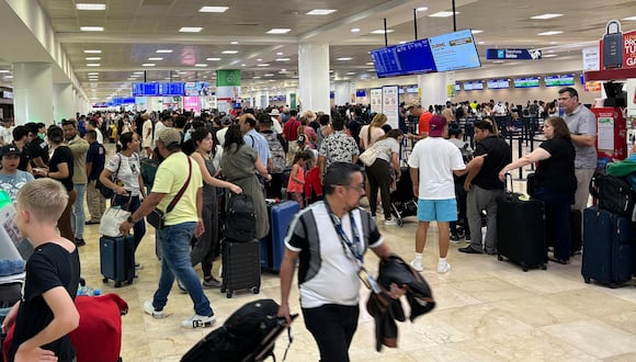 Pasajeros esperan para abordar un avión, este miércoles, en el aeropuerto de Cancún tras emitirse una alerta 'amarilla', que indica un peligro moderado, ante la cercanía del huracán Beryl. EFE/ Alex Cruz